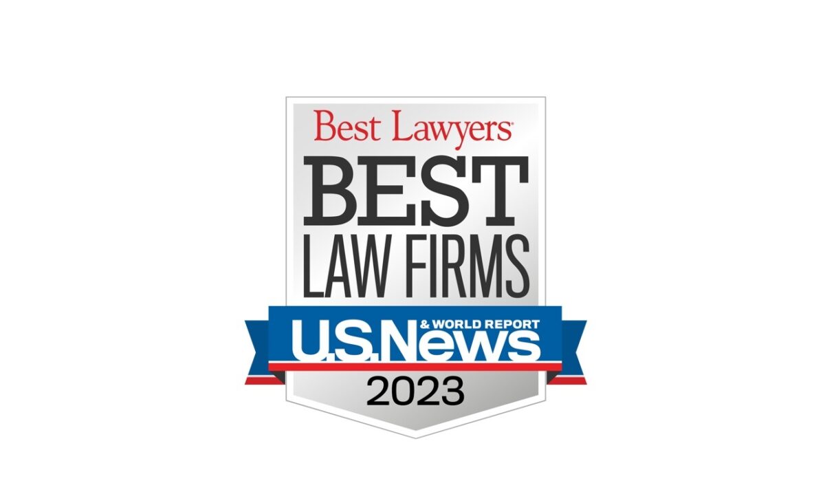 Logo for U.S. News & World Report "Best Law Firms 2023," featuring a shield design with red and blue accents and the text "Ansbacher Law" prominently displayed.