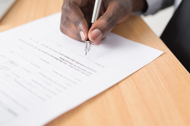 man signing document