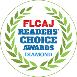 A circular badge with a green laurel wreath border. Inside, red and blue text reads: "FLCAJ Readers' Choice Awards Diamond.