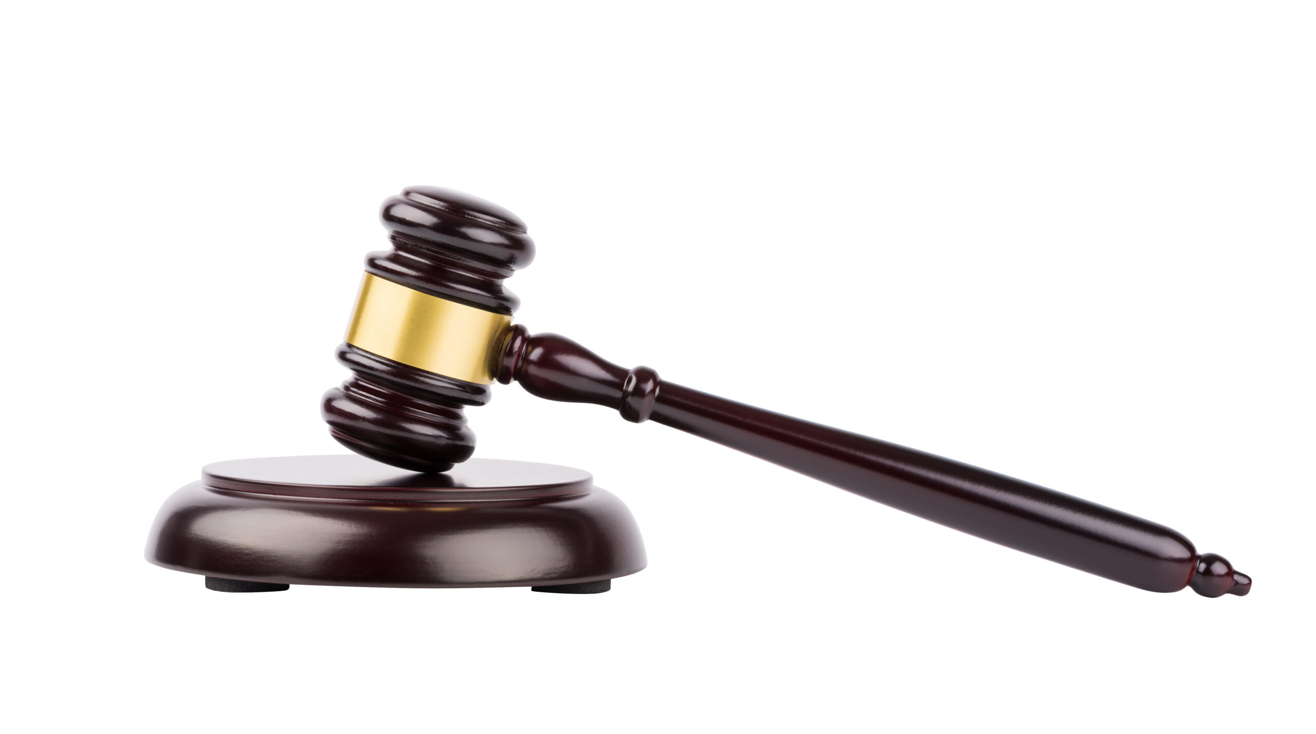 A wooden judge’s gavel with a gold band rests on a round sound block, symbolizing law and justice in Florida Courts, against a white background.